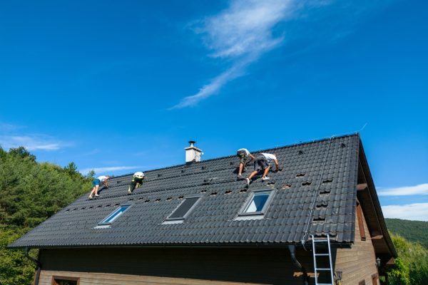 Men worker installing solar photovoltaic panels on a roof, alternative energy, saving resources and sustainable lifestyle concept.